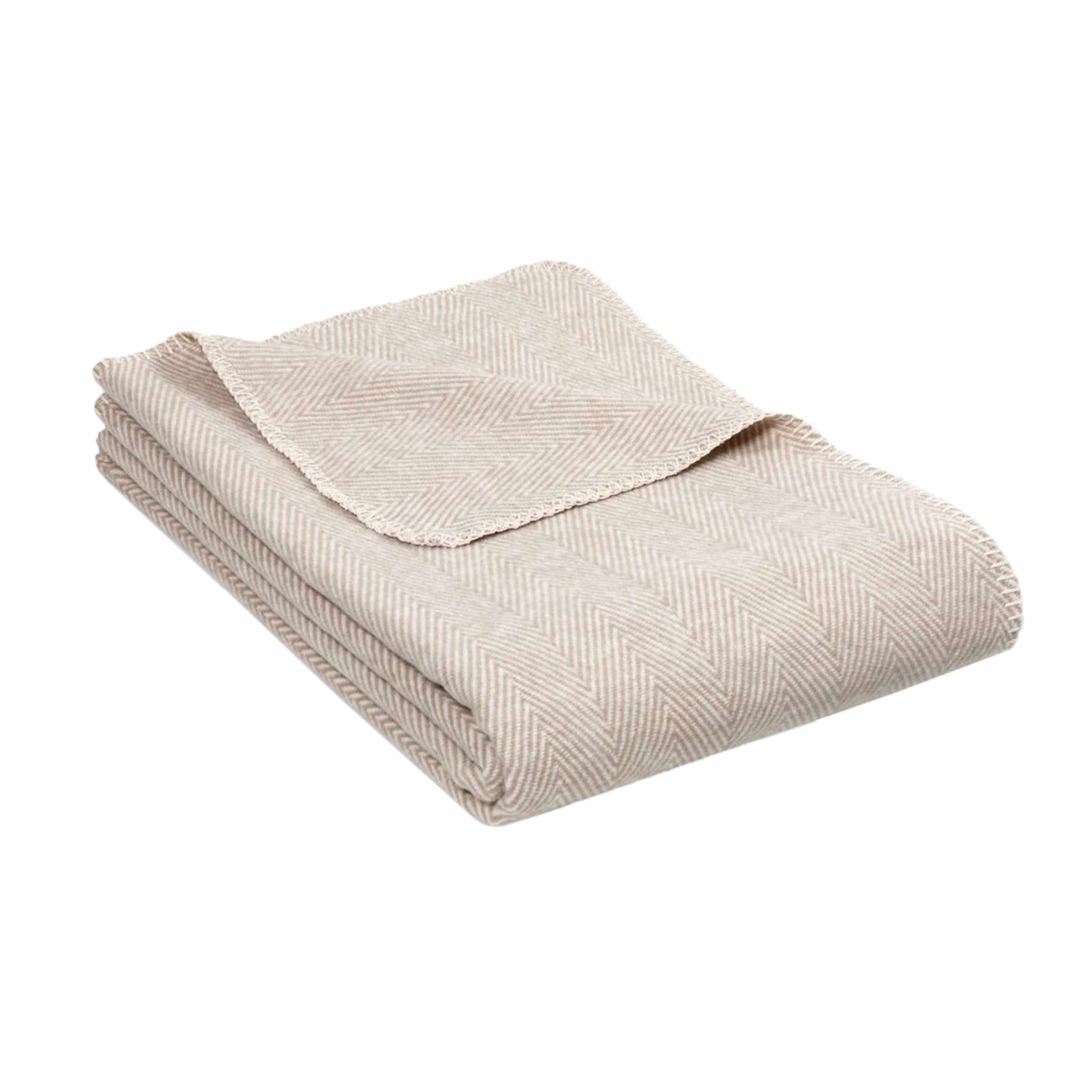 Beigefarbene Kuscheldecke mit feinem, gleichmäßigem Fischgrätmuster, ordentlich gefaltet auf hellem Hintergrund.