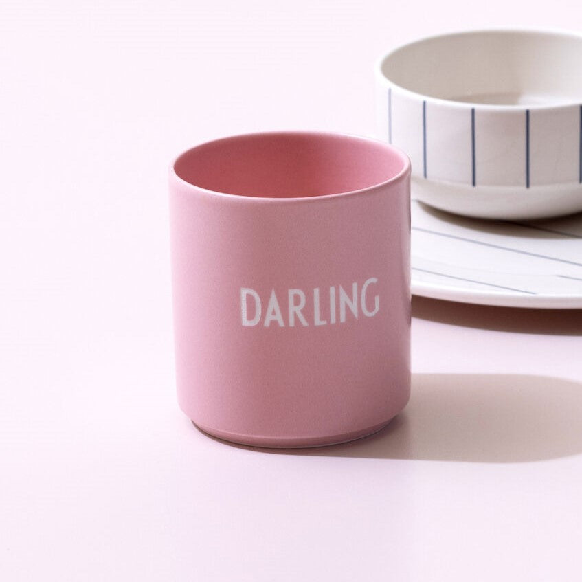 Becher pink mit Aufschrift Darling im Vordergrund vor anderem Geschirr