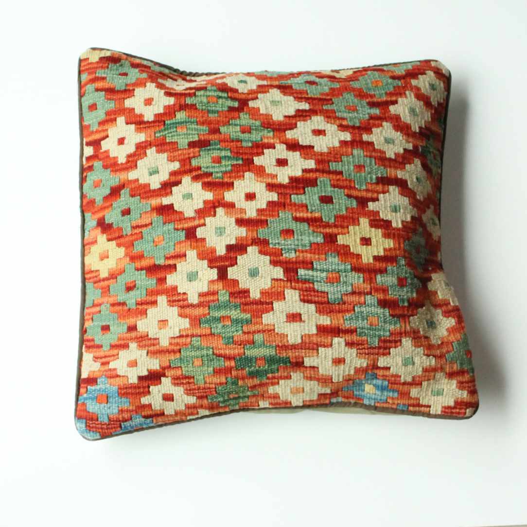 Kelim-Kissen 45x45 cm mit dichtem Rautenmuster in Rot, Grün, Beige und Türkis, handgewebt im traditionellen Stil mit geometrischem Blumenmotiv.