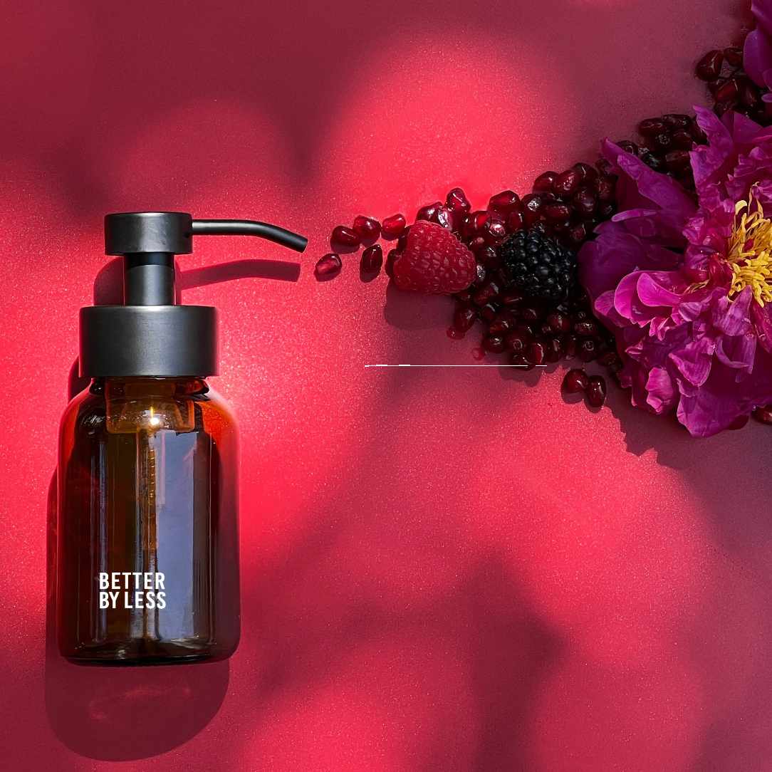 Packung mit Schaumspender in braunem Glas und schwarzem Spender mit Schaumpulver mit Duftrichtung Pomegranate Passion und Beerenabbildung