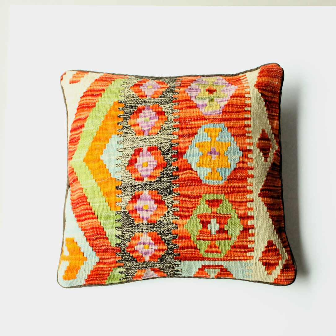 kelimkissen mit fröhlich buntem Muster in rot, grün, orange und pink